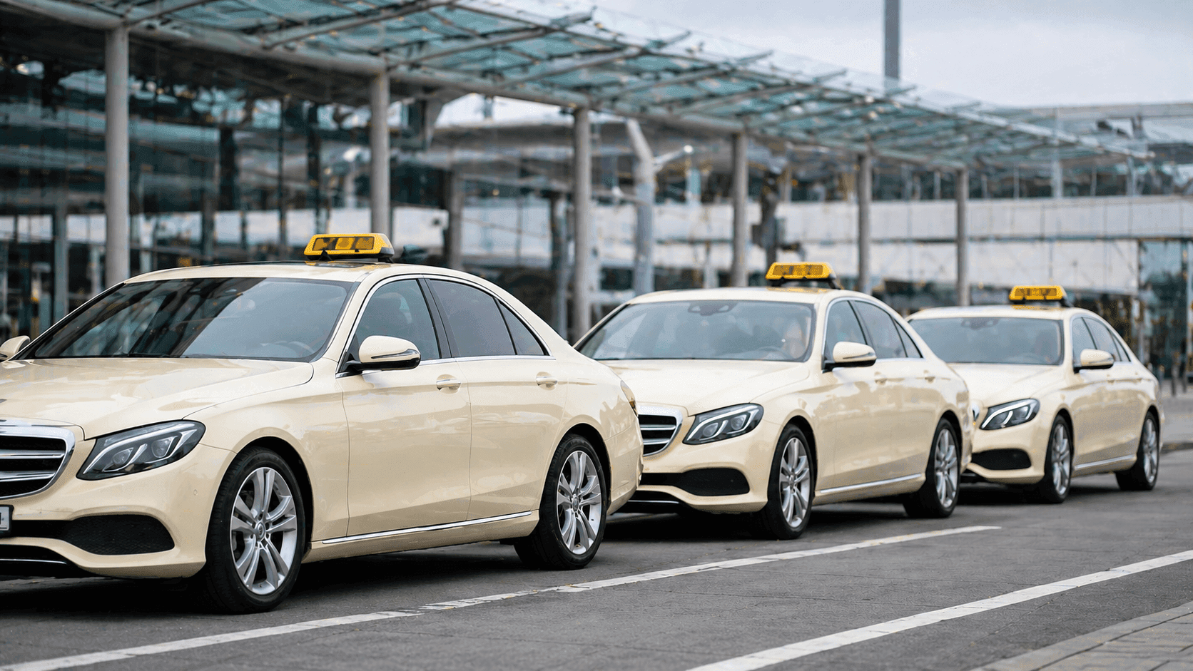 fleet of Mercedes E-Class taxis at Stuttgart Airport — fixed-price service